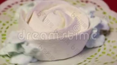 玫瑰形状的白色棉花糖。 带着花瓣。 在蕾丝餐巾上。 绕一个垂直轴旋转